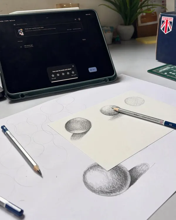 Back to basics. This is a shot of my practice sheets where I work on shading fundamental shapes like spheres. Mastering light and shadow on simple forms is key to creating realistic portraits.
