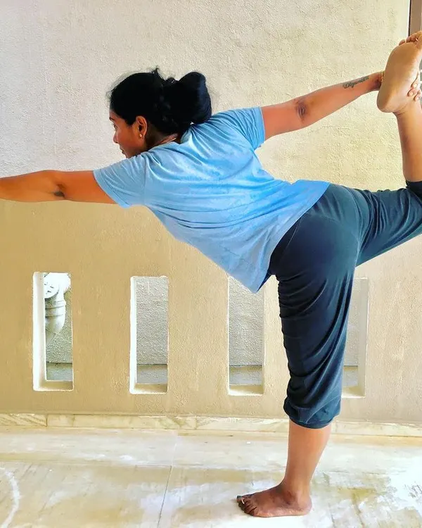 A student gracefully holding Natarajasana (Lord of the Dance Pose). This pose develops balance, flexibility in the spine, and strengthens the legs.