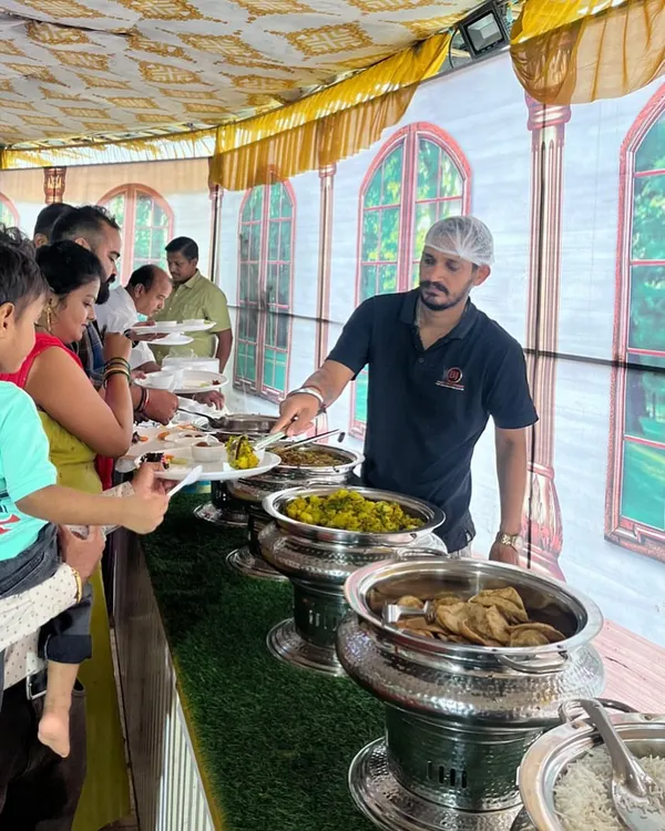 Here is my team serving guests at a recent house party. I provide a complete buffet setup with shiny steel handis and a professional team to make sure everyone enjoys the fresh, pure vegetarian food.