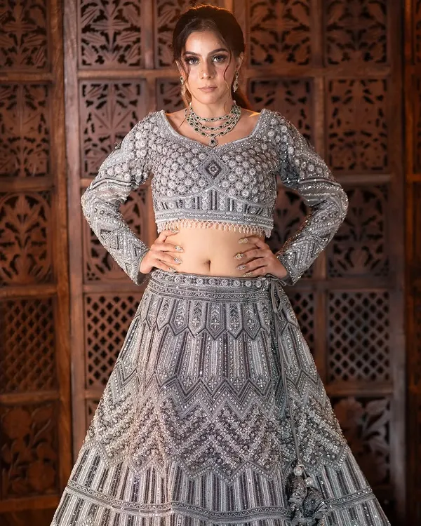 This silver-grey lehenga is a showstopper, perfect for a cocktail party or reception. The geometric sequin work is modern, and the full-sleeve blouse adds a touch of elegance.