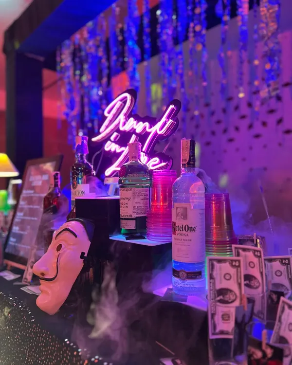 Our Money Heist themed bar in full swing. We bring the theme to life with details like Dali masks, prop money, and a custom "Drunk in Love" neon sign, creating an immersive experience for your sangeet or cocktail night.