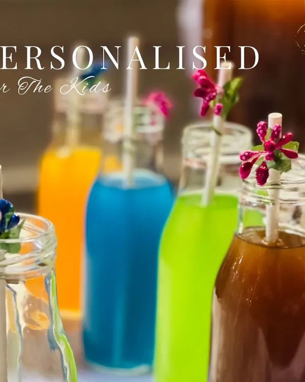 A colorful lineup of our personalized drinks for kids. Served in charming glass bottles with decorative floral straws, these fun beverages make children feel extra special at any celebration.