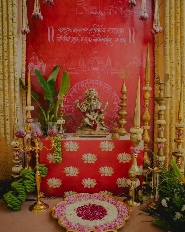 A sacred corner dedicated to Lord Ganesha, decorated in a traditional South Indian style with brass lamps, banana bunches, and a backdrop with Sanskrit verses.