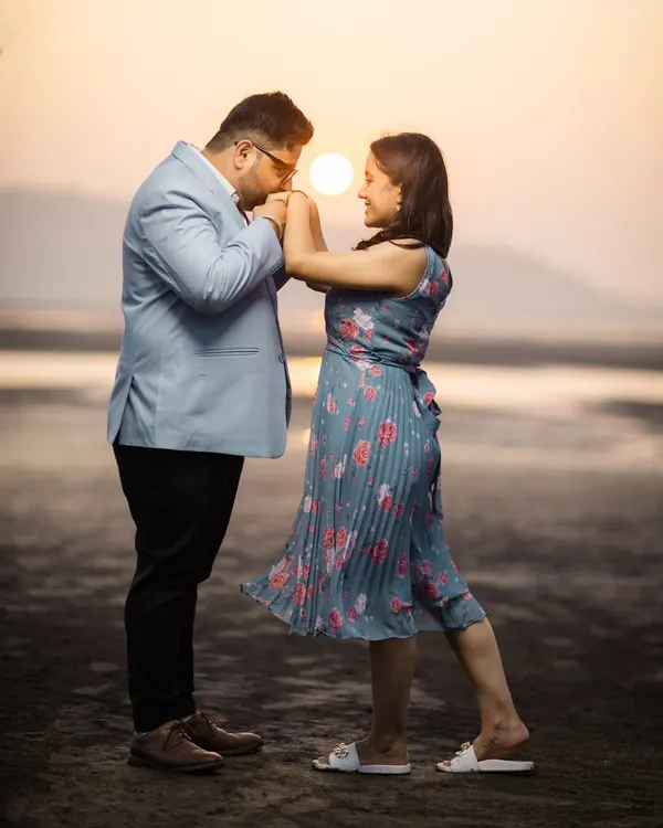 A classic romantic gesture at sunset, with the golden light creating a warm and intimate atmosphere. This silhouette shot on the beach is a timeless way to capture your connection.