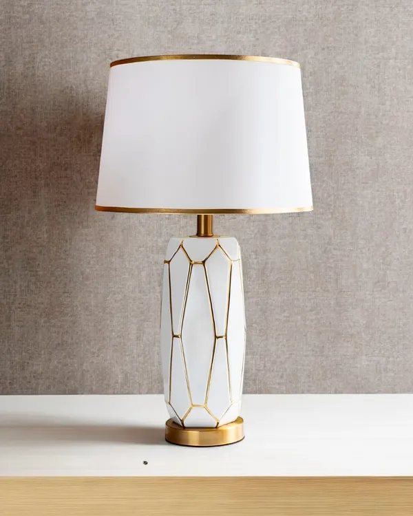 I love the simple elegance of this lamp. The white ceramic base features a geometric pattern outlined in gold, and the clean white shade is also trimmed in gold for a cohesive, luxurious feel. It's a perfect modern glam accent.