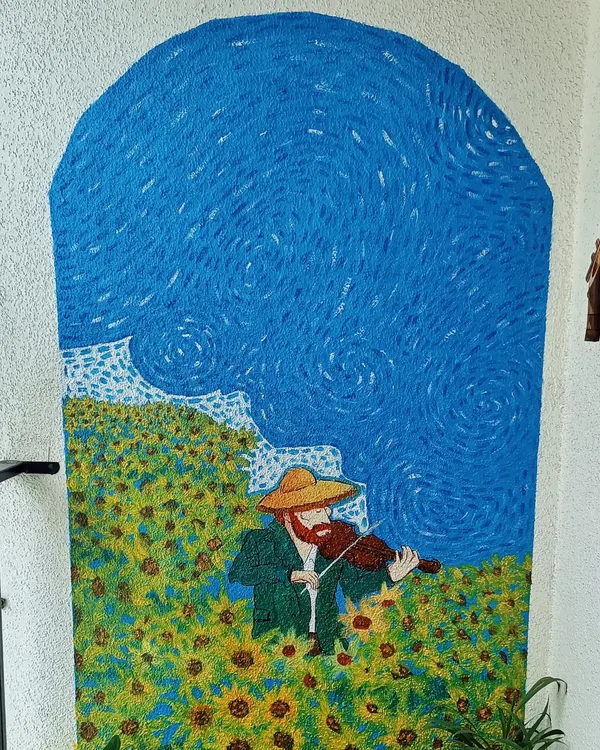 This balcony mural was inspired by Vincent van Gogh's style. I used his signature swirling brushstrokes and vibrant color palette to create this peaceful scene with a violinist in a sunflower field.