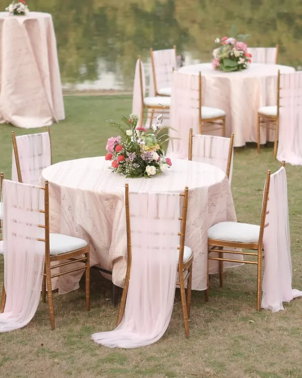 Elegance in every detail. For the 'Mantram' wedding, we styled the guest tables with soft pink linens, flowing chair drapes, and beautiful floral centerpieces that echoed the romance of the mandap.