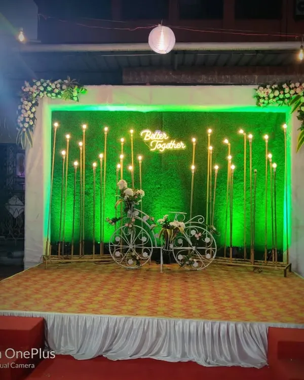 We love creating fun corners for guests to take pictures. This charming selfie point features a decorative bicycle and a "Better Together" neon sign against a lit-up green wall.
