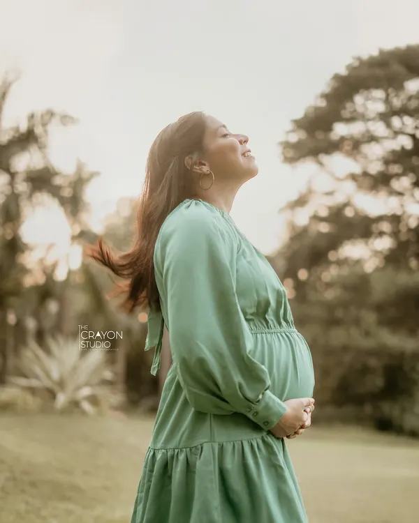 A moment of pure bliss during an outdoor maternity shoot. With her eyes closed and face turned to the sun, she soaks in the peacefulness of this fleeting time.