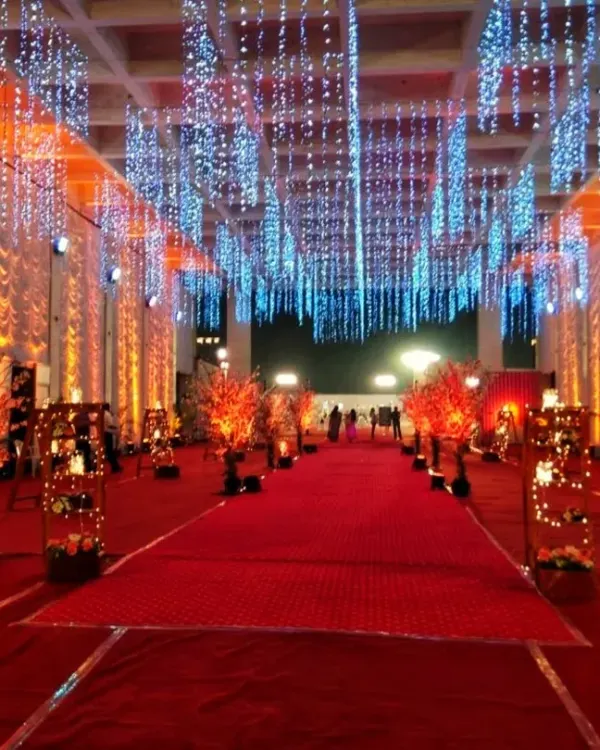 This is the kind of grand entrance I create for large-scale events. I use a combination of structural elements, dramatic overhead string lighting, and a classic red carpet to make sure guests feel the impact from the moment they arrive.