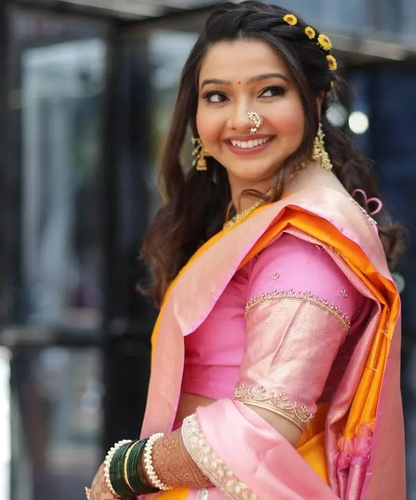 The quintessential Maharashtrian bride, looking radiant and happy. I created a fresh, minimal makeup look with a simple hairstyle to perfectly complement her beautiful pink and yellow Paithani saree.