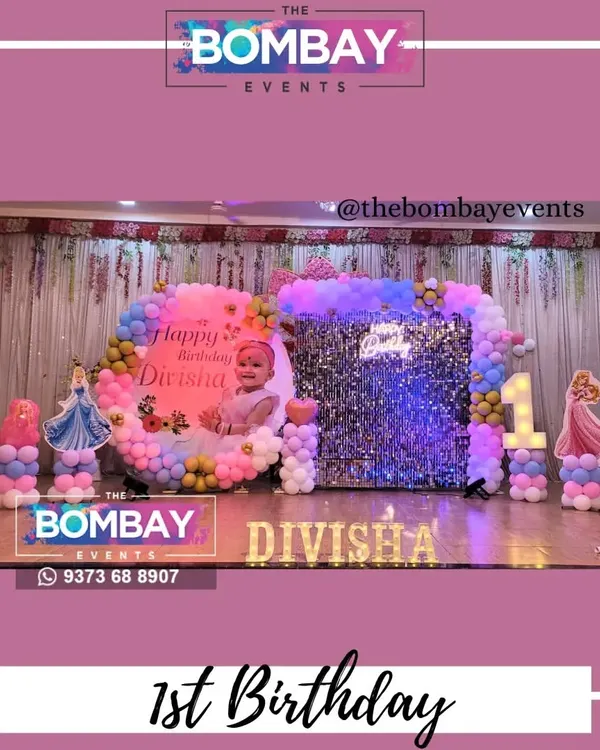 A dreamy first birthday for a little princess. This large-scale setup includes a personalized backdrop, a silver sequin wall, a pastel balloon arch, and cutouts of different Disney princesses.