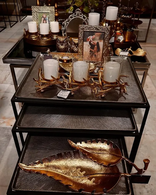 A beautiful display in my store featuring a mix of gold and silver decor, including candle holders, photo frames, and decorative leaf platters.