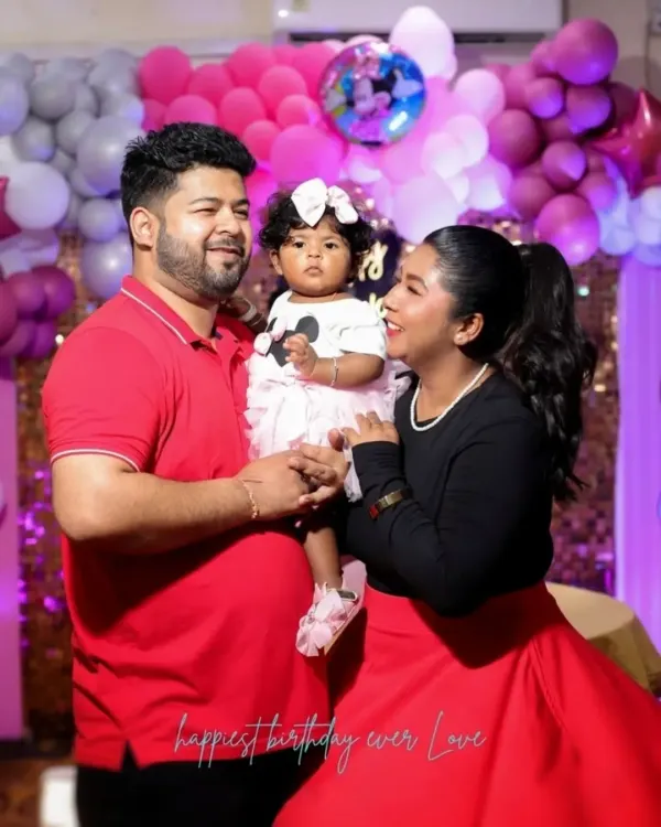 A happy family portrait at a first birthday party with a pink and white balloon backdrop. We ensure we get that perfect family shot you can cherish forever.