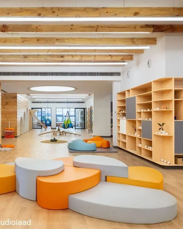 At the Heritage International School, we designed large, open activity centers to encourage unimpeded movement and exploration. The space features modular, pebble-like seating, natural wood finishes, and exposed ceiling beams, creating a warm, playful, and free-flowing learning environment.