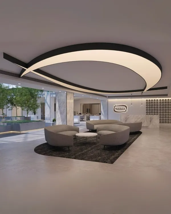 The reception at Hamdard Laboratories HQ features a dramatic, custom-designed light fixture that mirrors the brand's logo. This space sets a modern and sophisticated tone, welcoming visitors into an office centered around wellness and natural elements.