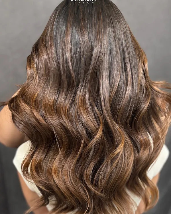 This is the caramel balayage dream. I created these flowing waves to show off the seamless blend of deep brown and warm caramel tones.
