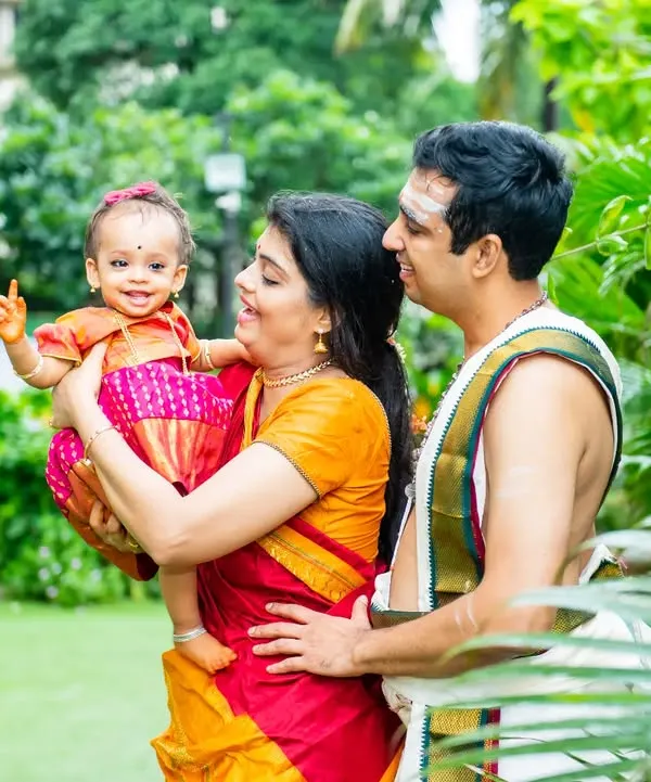 A beautiful family portrait from an Ayusha Homam ceremony, with the parents and baby dressed in traditional South Indian attire.