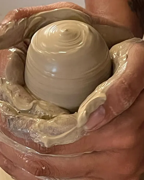 The quintessential moment of creation on the potter's wheel. This image captures the feeling of centering clay, the first step in transforming a simple lump of earth into a beautiful, functional vessel.