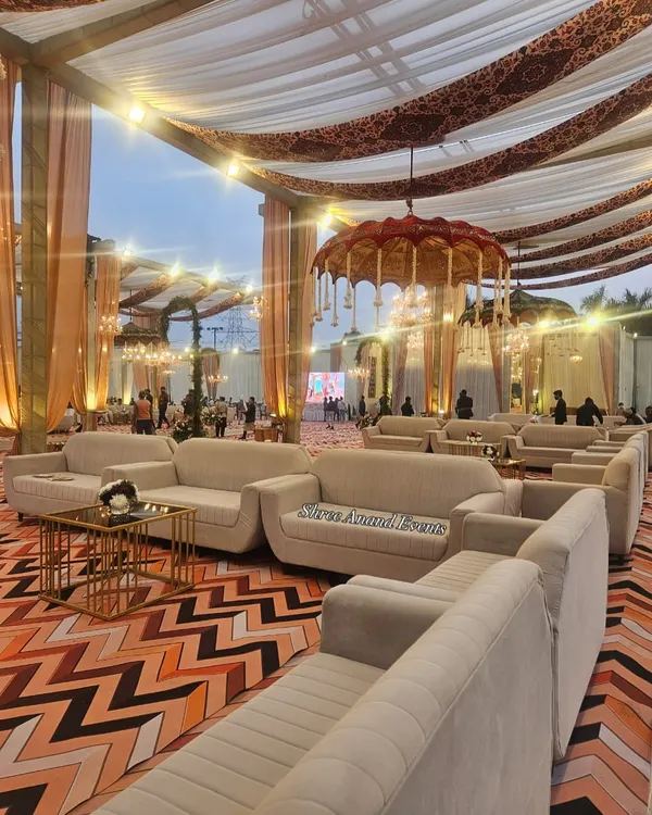 A wide view of the guest seating area, featuring comfortable sofas, elegant draping, and a traditional hanging umbrella as a centerpiece.