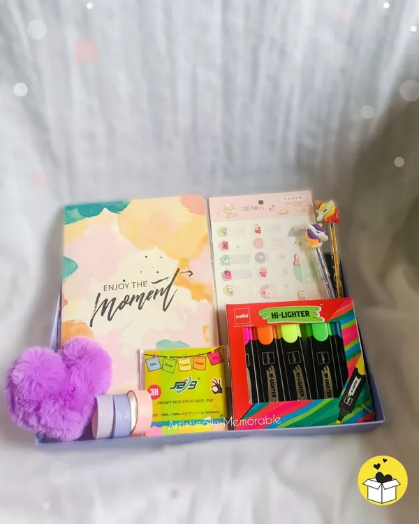 A fun and colorful stationery hamper, perfect for a little sister or niece's birthday. It's filled with a notebook, highlighters, washi tapes, and a fluffy heart keychain.