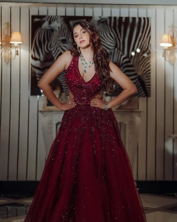 Ready for a night of glamour. This full length shot shows a stunning red gown, perfect for a Sangeet or reception. The makeup is bold and confident, designed to make a statement.
