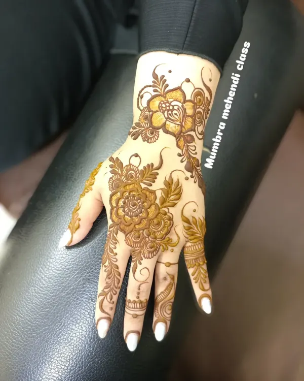 A beautiful, full floral piece on the back of the hand. The shading on the petals gives it a very realistic look.