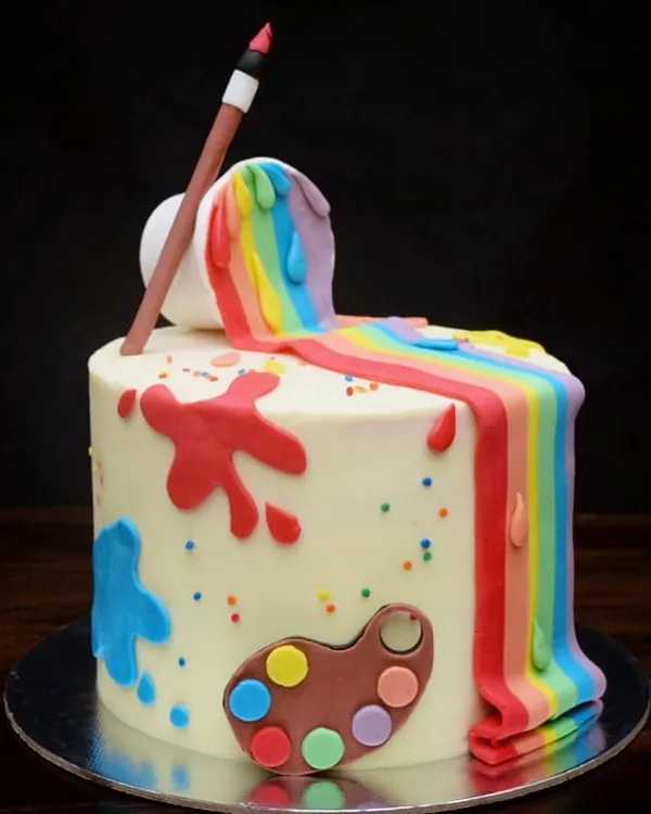 I created this fun artist-themed cake for a creative soul. It features a rainbow waterfall of fondant paint spilling from a bucket, paint splatters, and a little artist's palette, with vibrant rainbow layers hidden inside.