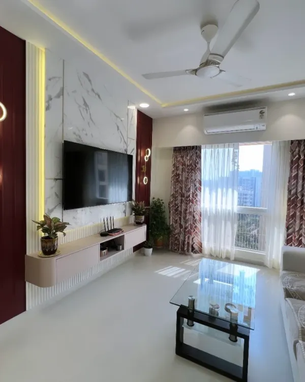 A stunning living room in Andheri, where deep burgundy tones and marble textures create a sense of modern opulence. The custom TV unit and ambient lighting make this the perfect space for both relaxing and entertaining.