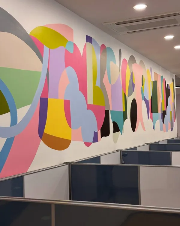 This 42-foot abstract mural brings a wave of color and energy to an office cubicle area. The design is a visual rhythm of interlocking shapes and vibrant hues, meant to inspire creativity and connection in the workplace.