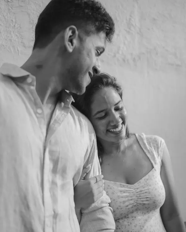 A soft and intimate black and white portrait. The genuine smiles and gentle embrace convey a deep sense of comfort and affection, creating a timeless and emotional image.