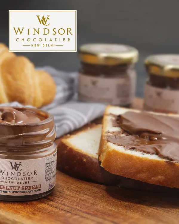 Our Hazelnut Spread is perfect for more than just toast. Here it is shown with fresh bread and a croissant, illustrating its use as a delicious, high quality spread for cafes and bakeries.