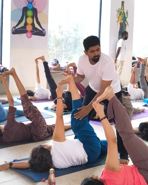 A moment from our soulful yoga retreat in Rishikesh. Here, our instructor gives a hands-on adjustment, ensuring each participant gets personalized attention even in a group setting.