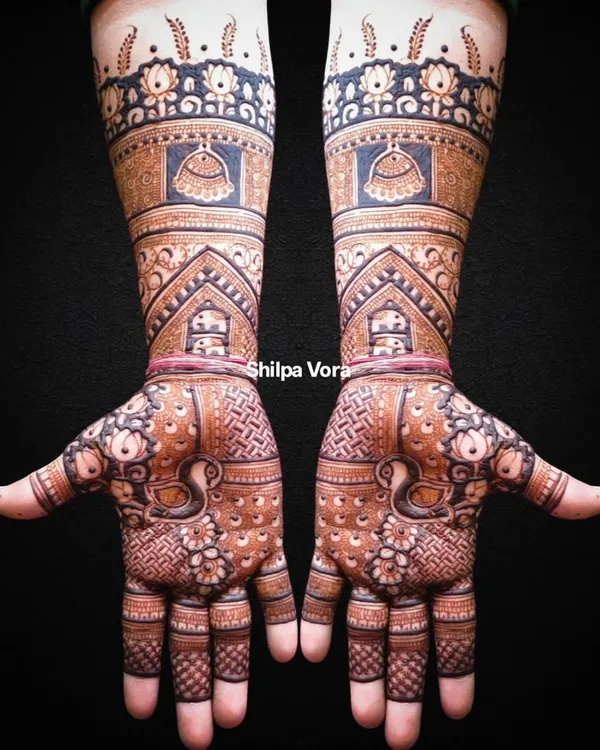 A full bridal arm design with incredible detail, featuring domes, peacocks, and intricate filler patterns.