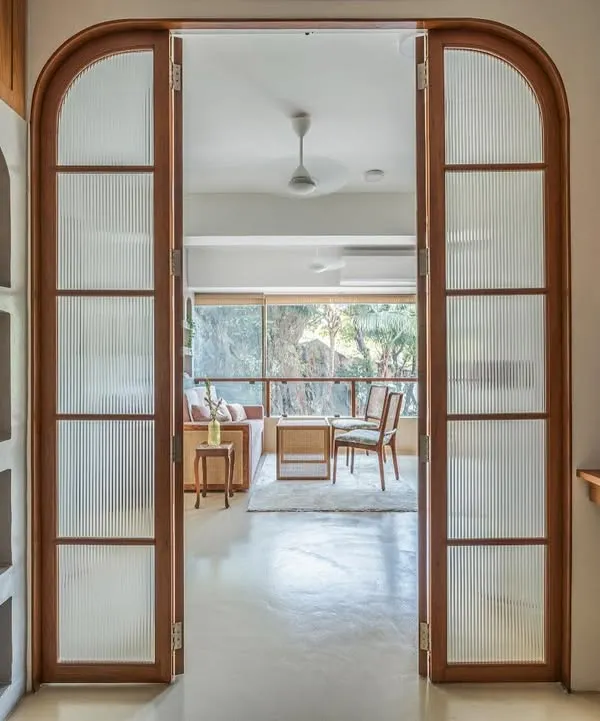 A view from the workspace into the consultation area of the nutrition clinic. The arched, fluted glass doors create a beautiful transition between the two zones while maintaining a sense of openness and light.