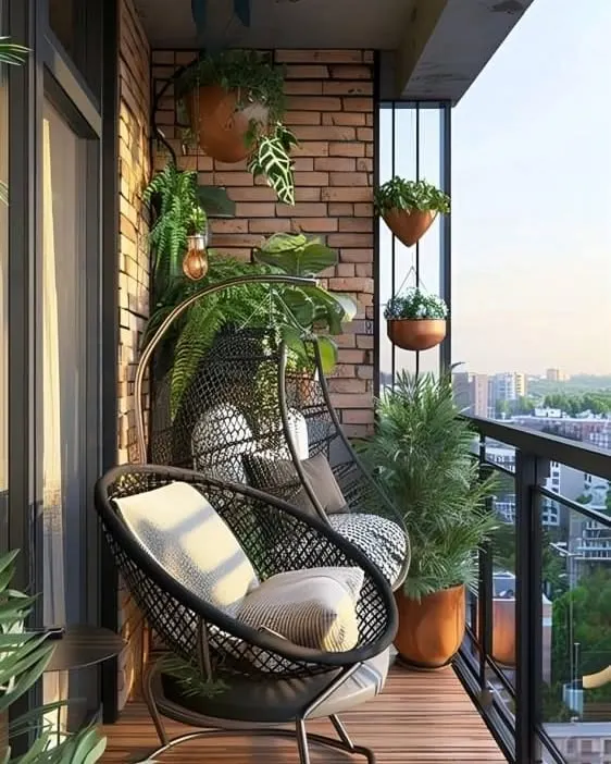 This cozy corner features modern black wicker swing chairs against an exposed brick wall. With comfortable cushions and surrounded by hanging plants, it’s an inviting spot to unwind with a view of the city.