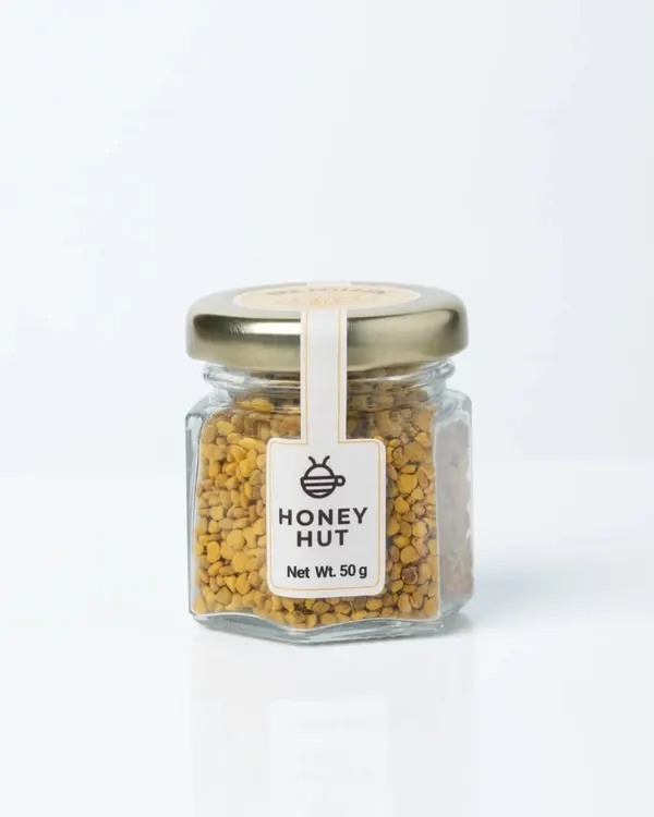 A clear, front-facing shot of a jar of Honey Hut Bee Pollen on a pure white background. This is a perfect example of an Amazon-ready primary product image.