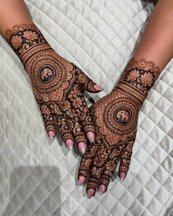 A beautiful full-hand design with a central elephant mandala. The surrounding pattern is a mix of fine lines and bold floral work.