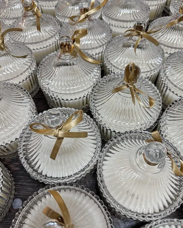 These elegant crystal jars filled with scented soy wax are a timeless choice for wedding favors. The intricate glass design catches the light beautifully, and the gold ribbon adds a touch of celebration.