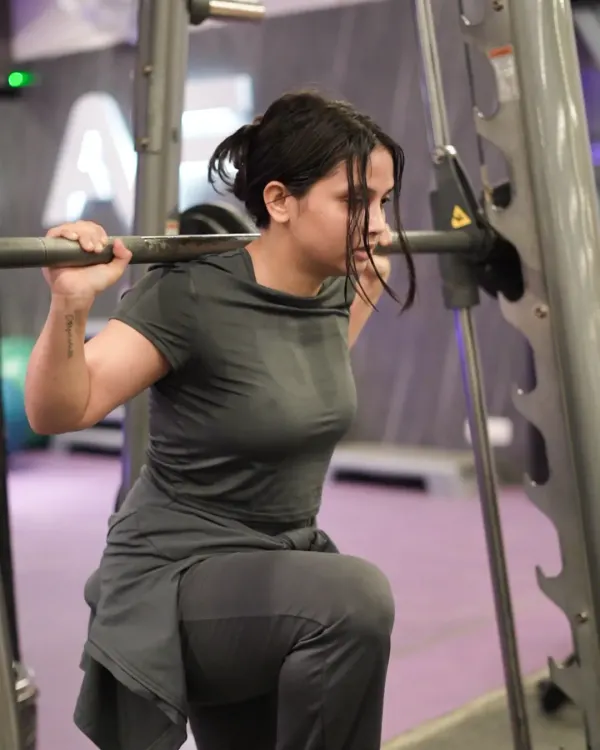 This client performs a lunge on the Smith machine, a great exercise for building leg strength and stability with added support.