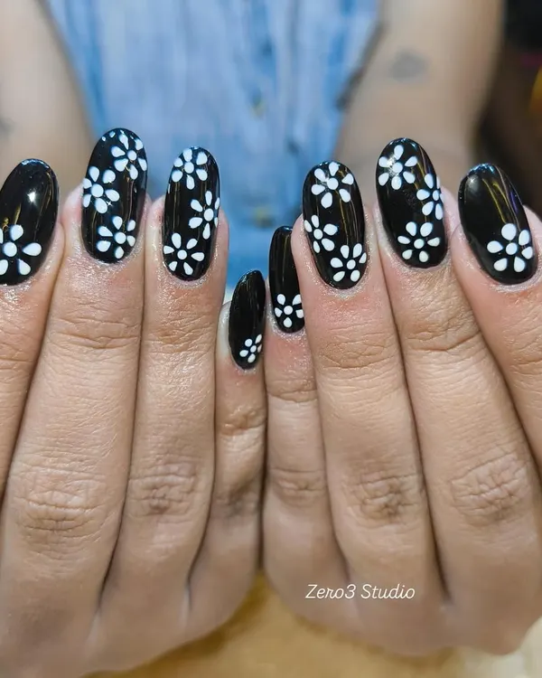 A classic black and white combination with a delicate floral pattern. This hand-painted design on glossy black gel polish offers a chic and timeless look for any occasion.