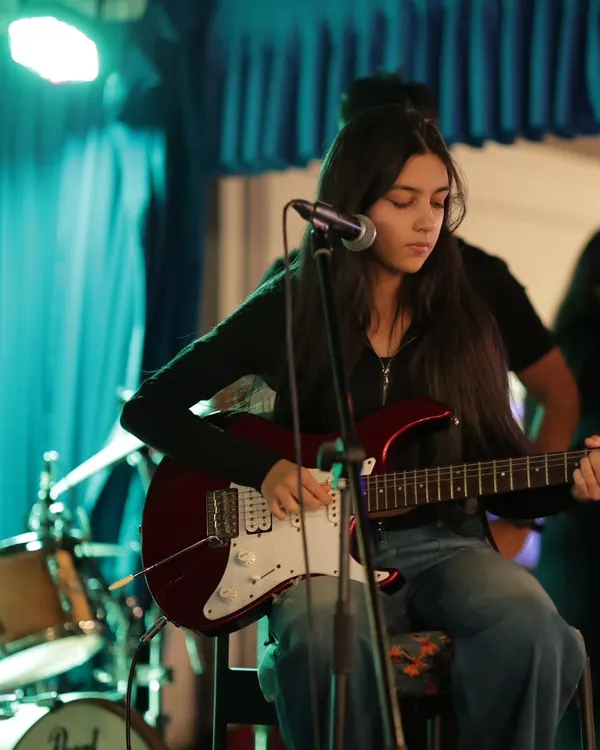 Focused and in the zone. A student guitarist nails her part during our annual Rhapsody in Radiance showcase. We prepare our students not just to play, but to perform with stage presence.
