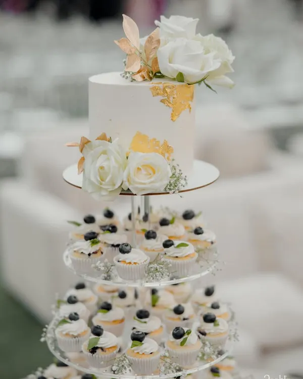 A moment of appreciation for this splendid cupcake tower. The simple elegance of the white and gold tiered cake, paired with fresh blueberry cupcakes, created a stunning centerpiece for a wedding.