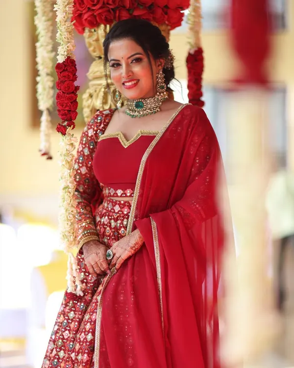 A closer look at the rich red reception lehenga, highlighting the detailed embroidery and flattering fit.