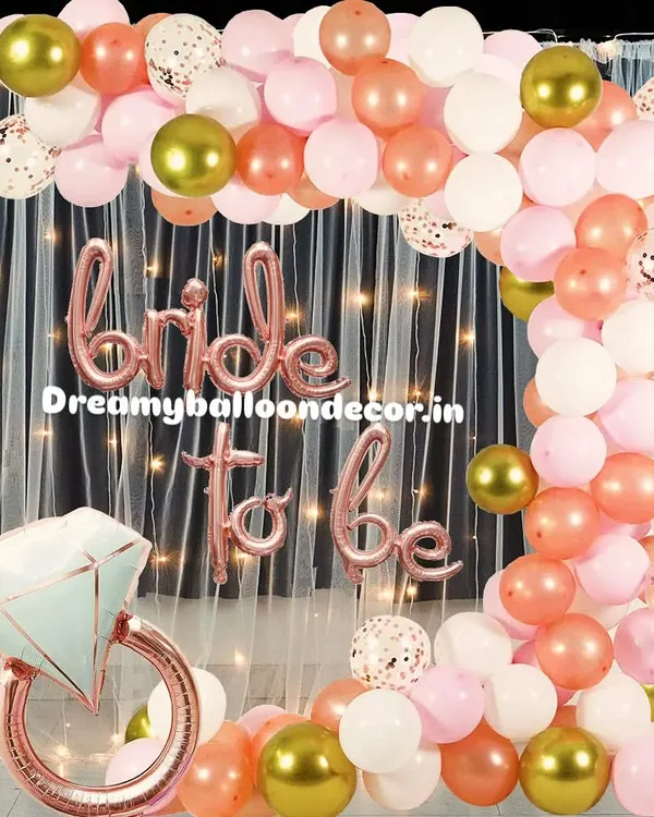 This is my popular rose gold 'Bride to be' package. It includes a beautiful balloon arch with white, pink, and confetti balloons, a large diamond ring prop, and a fairy light curtain for a perfect photo backdrop.