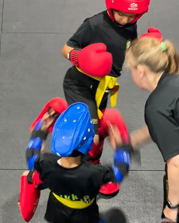 Learning to spar can feel scary, but we break it down every step of the way. Here, our coach guides young students, ensuring they learn at their own pace in a safe environment.