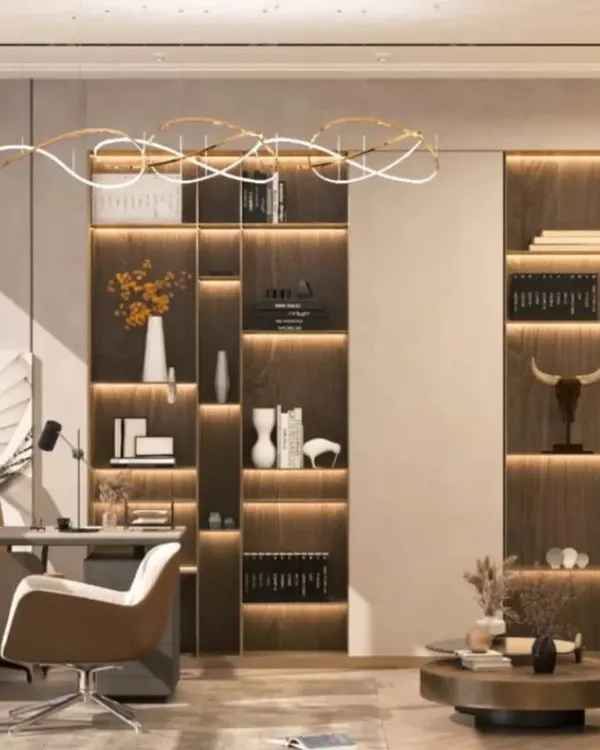 We designed this modern C-suite office to be a statement of leadership and clarity. The design features integrated shelving with warm backlighting, a sculptural overhead light fixture, and a clean, neutral palette to create an environment that is both impressive and conducive to focused work.
