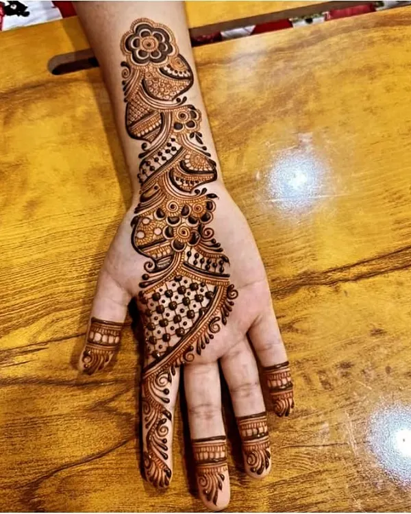 This is a popular Arabic-style design, featuring a floral vine that flows diagonally across the back of the hand. It's elegant and doesn't require full coverage.