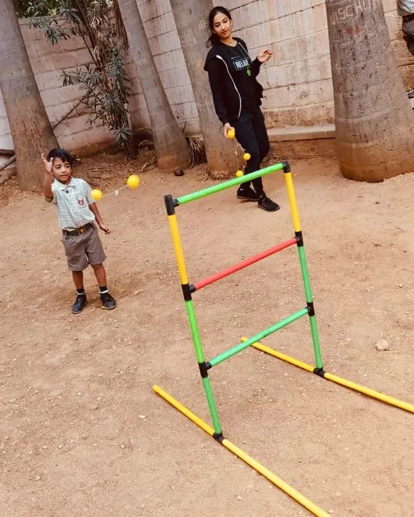 A young student practices his aim with a fun ladder toss game. This activity is excellent for developing hand-eye coordination and learning to control force and trajectory.