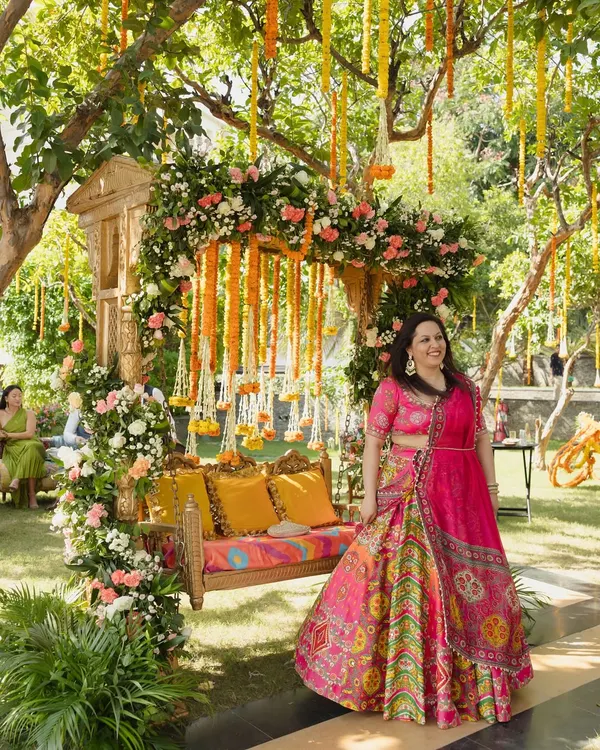 A beautiful photo from a garden Mehendi, where I designed a traditional wooden swing (jhoola) completely covered in pink and white roses with hanging marigold strings.